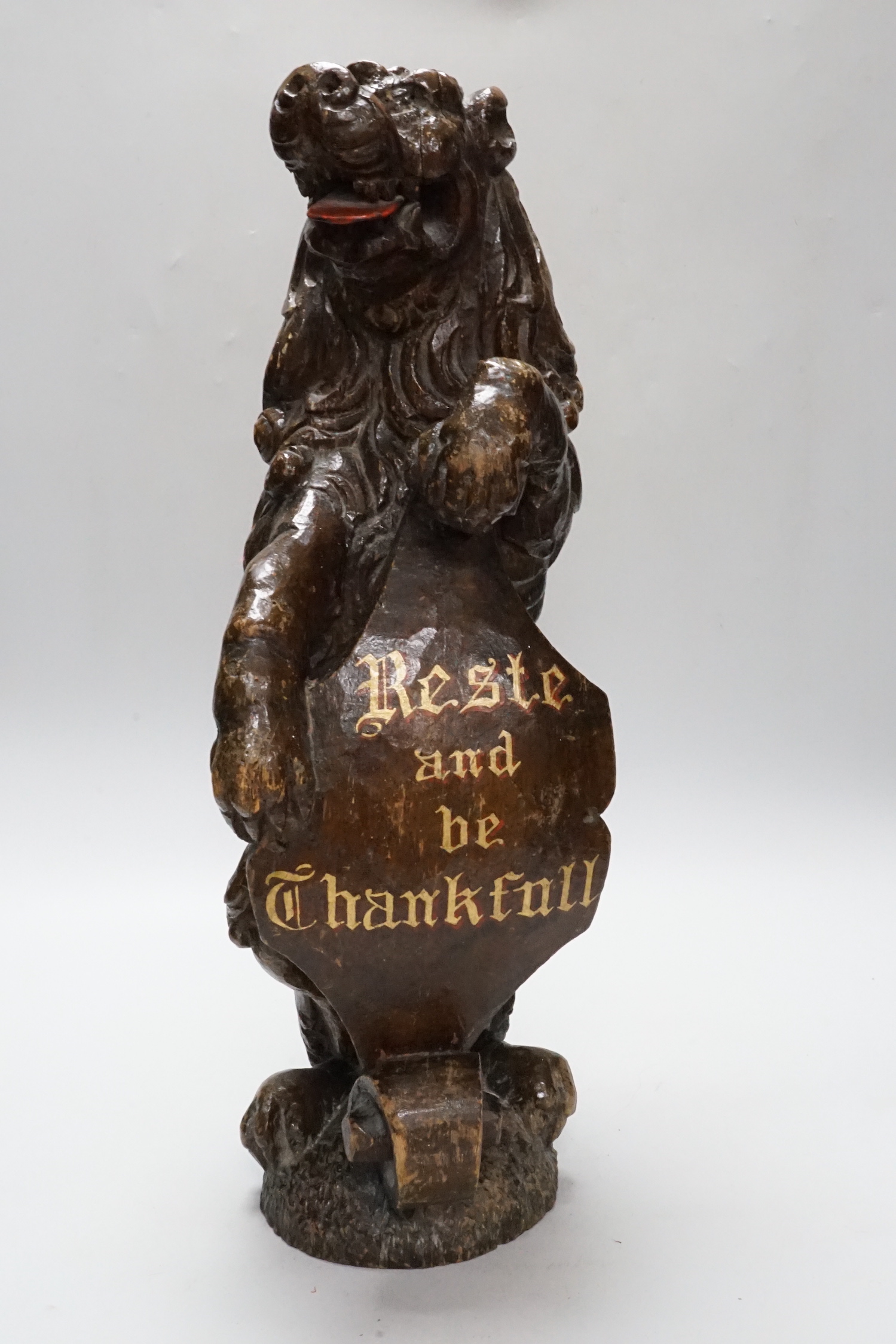 A carved oak lion holding a shield with inscription, possibly 17th/18th century with Victorian inscription Reste and be Thankfall, 48cm high